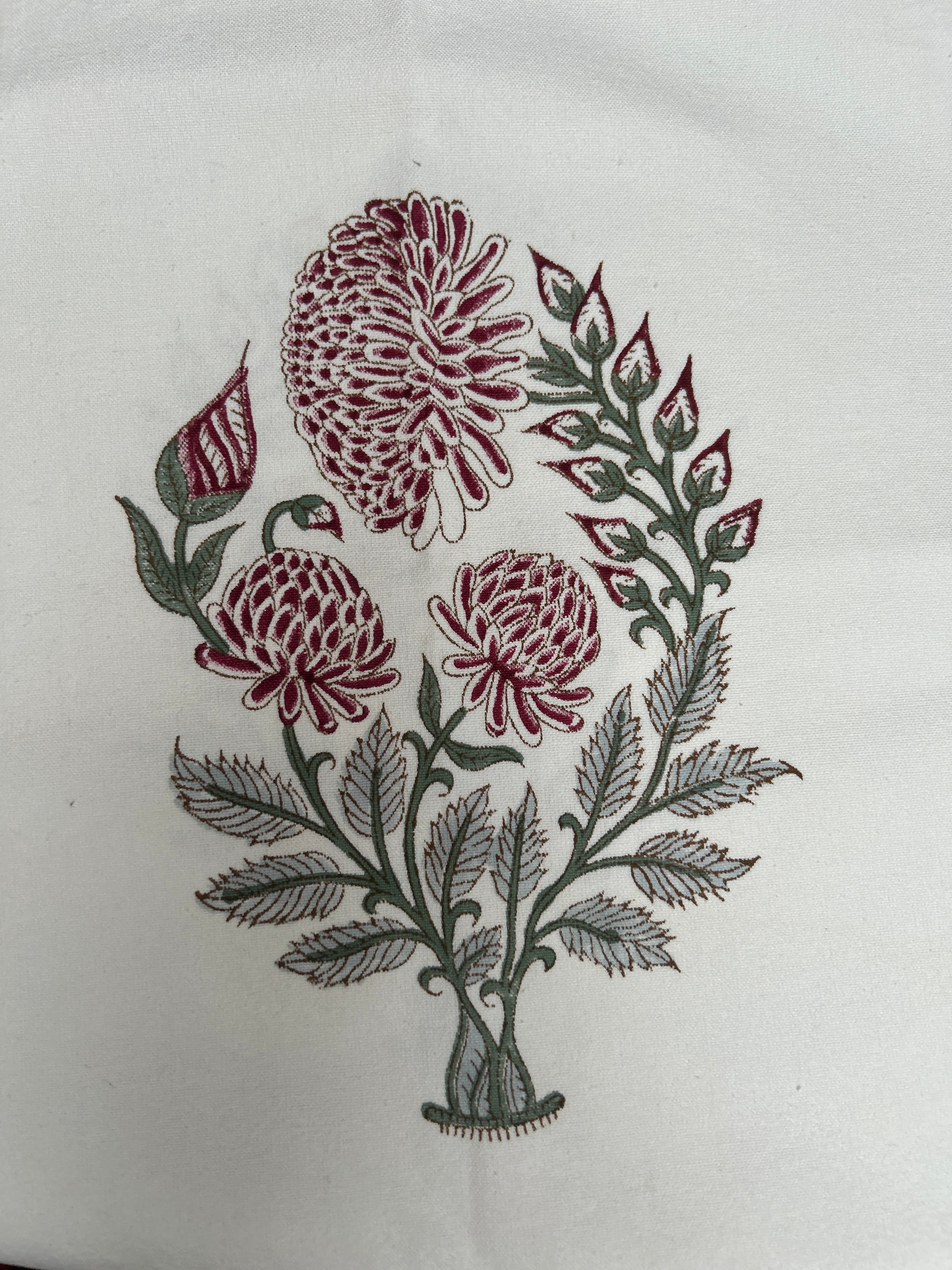 Embroidered design of flowers and leaves on a white fabric background The Charpoy