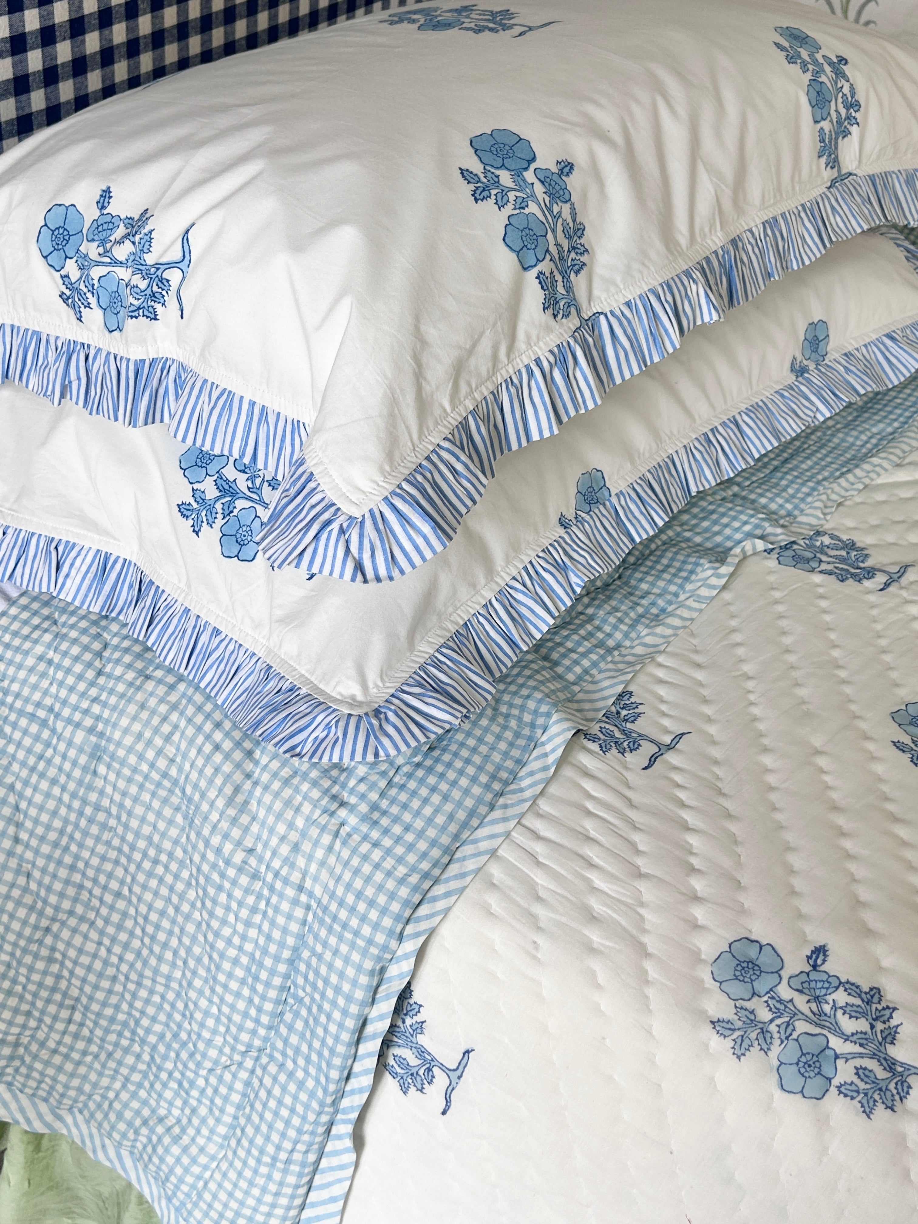 Jodhpur Blue Floral Hand Block Printed Quilt on a bed with matching pillows and checkered reverse, artisanal made in Jaipur by The Charpoy