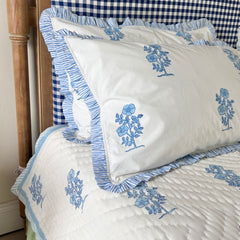 Jodhpur Blue Floral Hand Block Printed Quilt on a bed with checkered headboard with matching pillows, artisanal made in Jaipur by The Charpoy