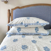 Jodhpur Blue Floral Hand Block Printed Quilt on a bed with matching pillows, artisanal made in Jaipur by The Charpoy