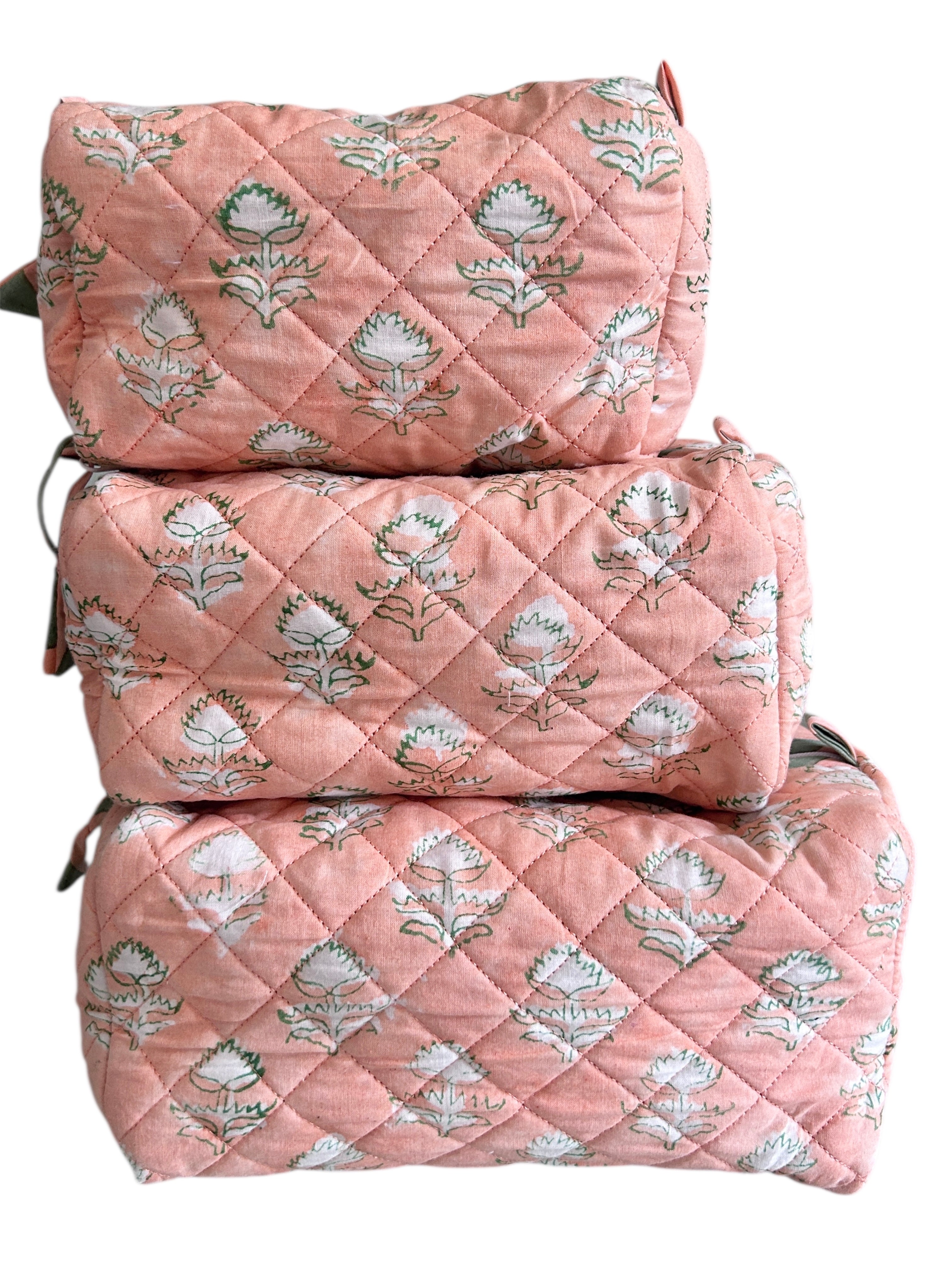 Set of three peach quilted wash bags with floral pattern on a white background The Charpoy