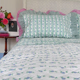 Petit blue flowers hand block printed king bedspread in pure cotton muslin, styled on a bed with coordinated striped pillows by The Charpoy