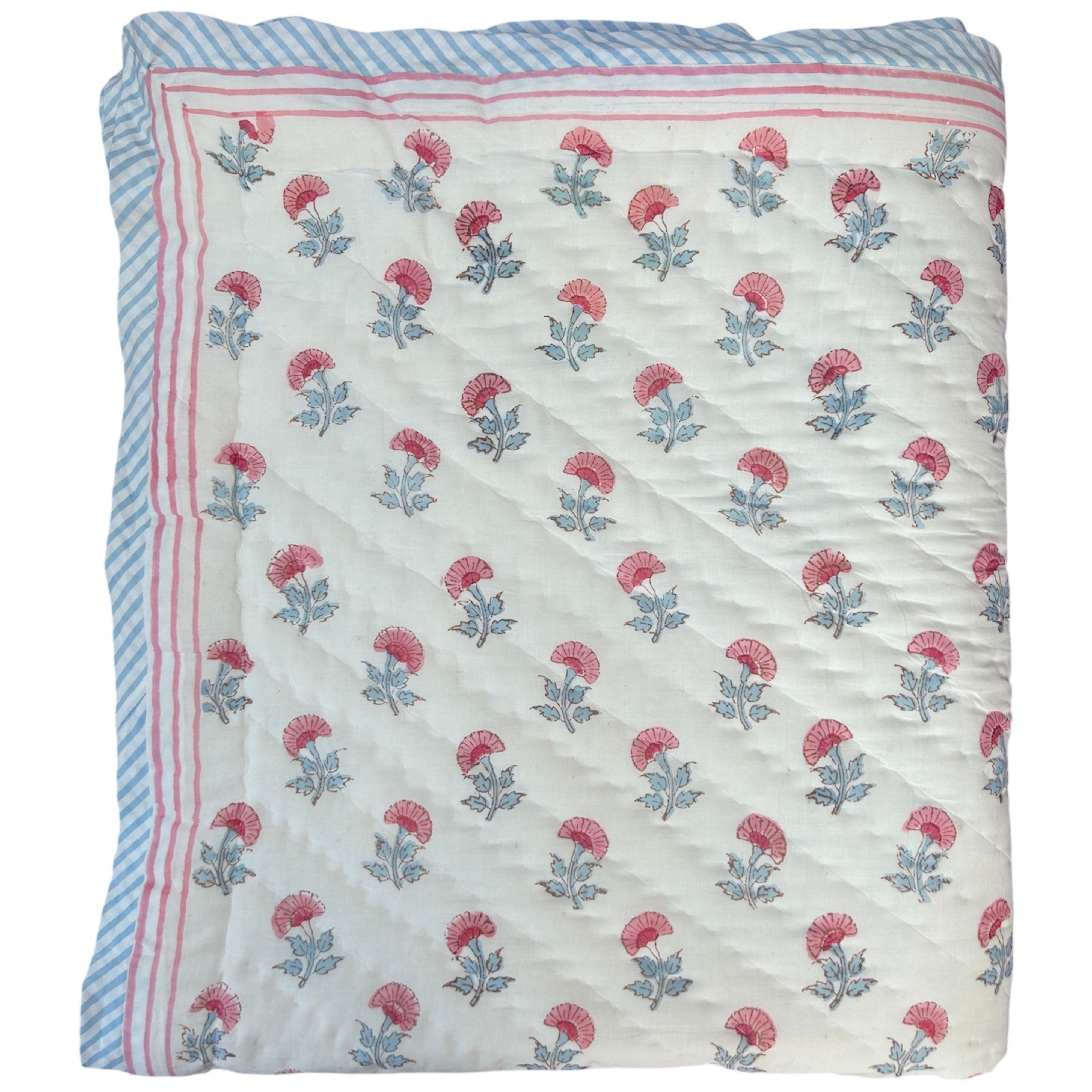 Pink and blue carnation hand block printed cotton quilt by The Charpoy on a white background