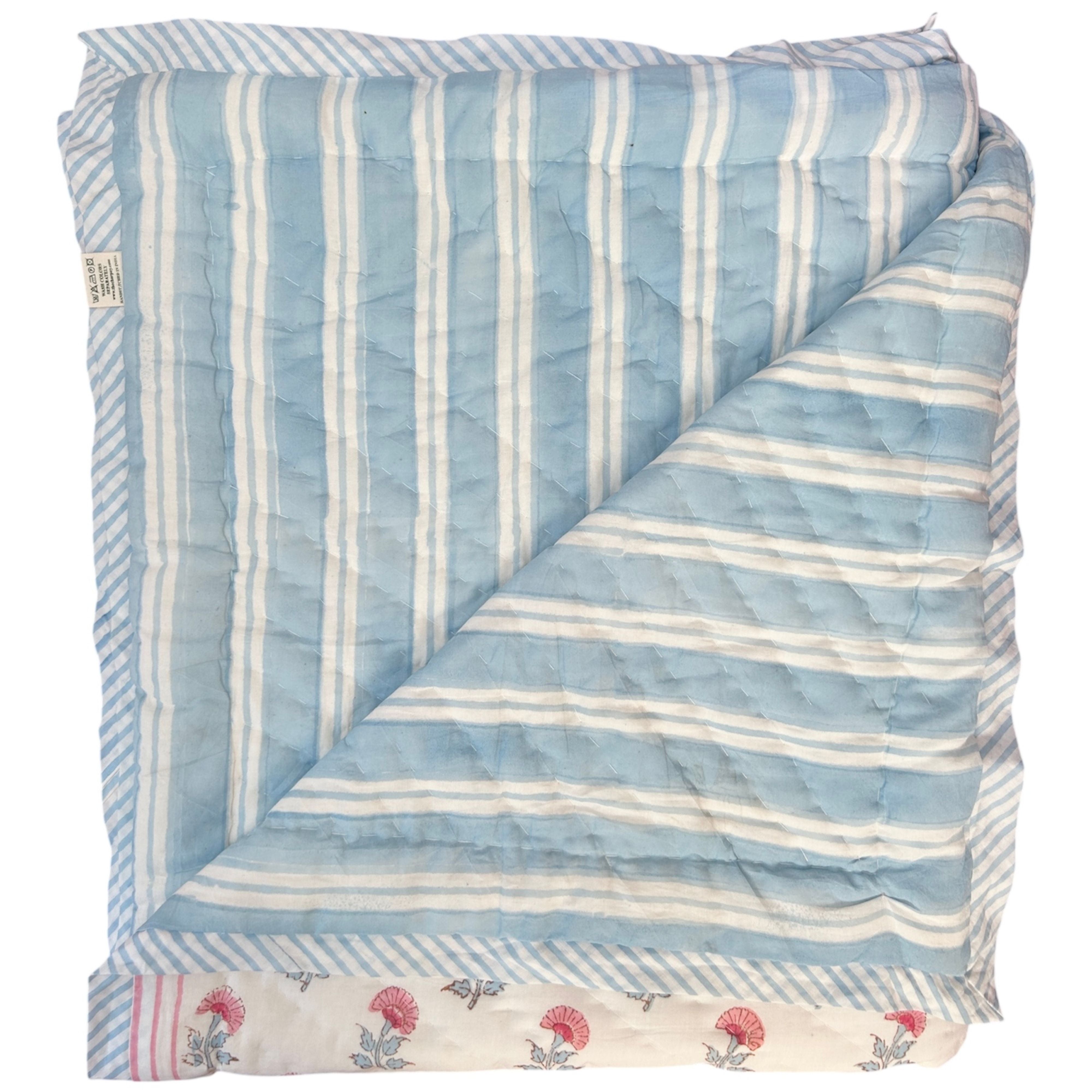 Reverse of pink and blue carnation hand block printed quilt showing blue and white striped pattern by The Charpoy