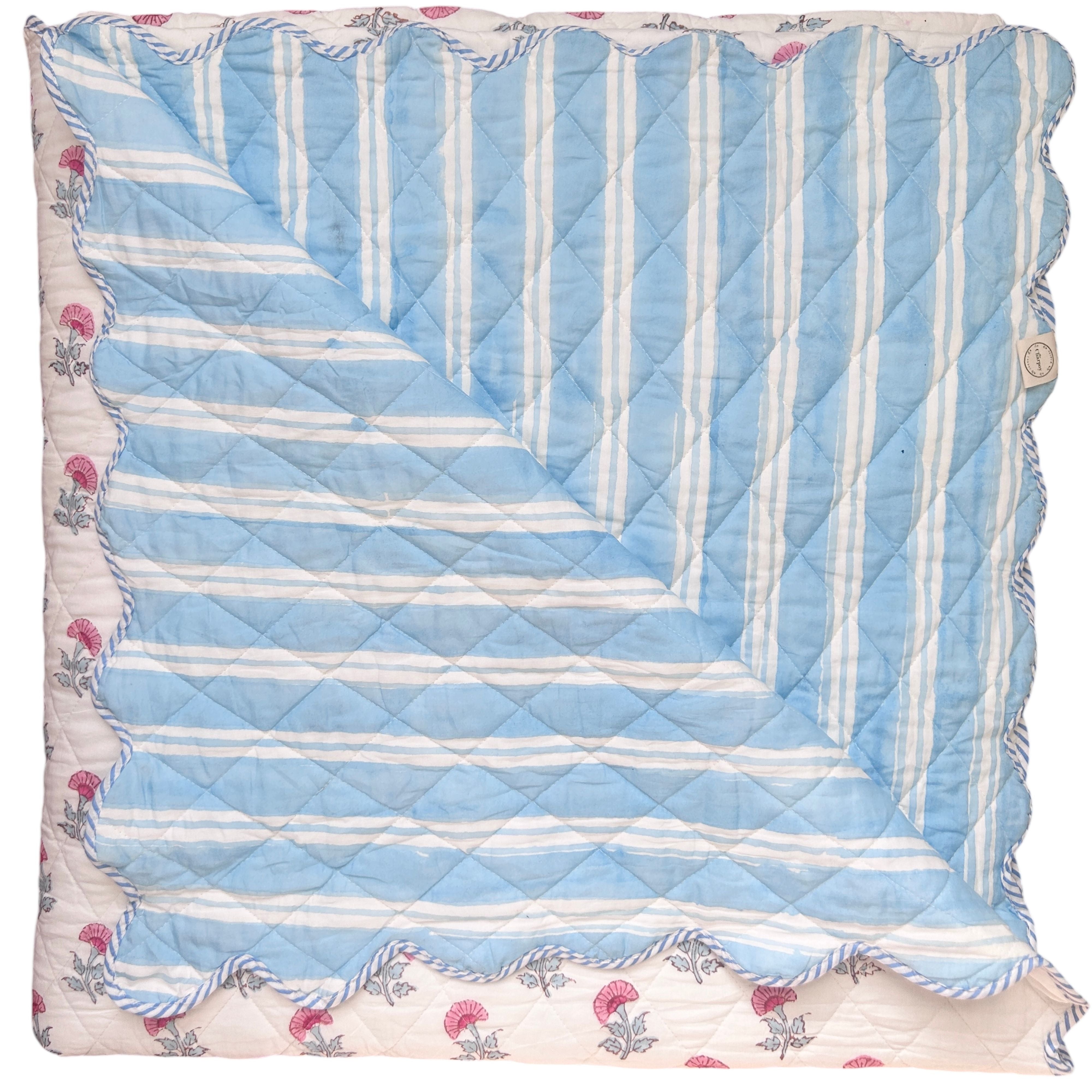 scalloped bedpread with blue and white striped pattern on reverse and floral pattern The Charpoy