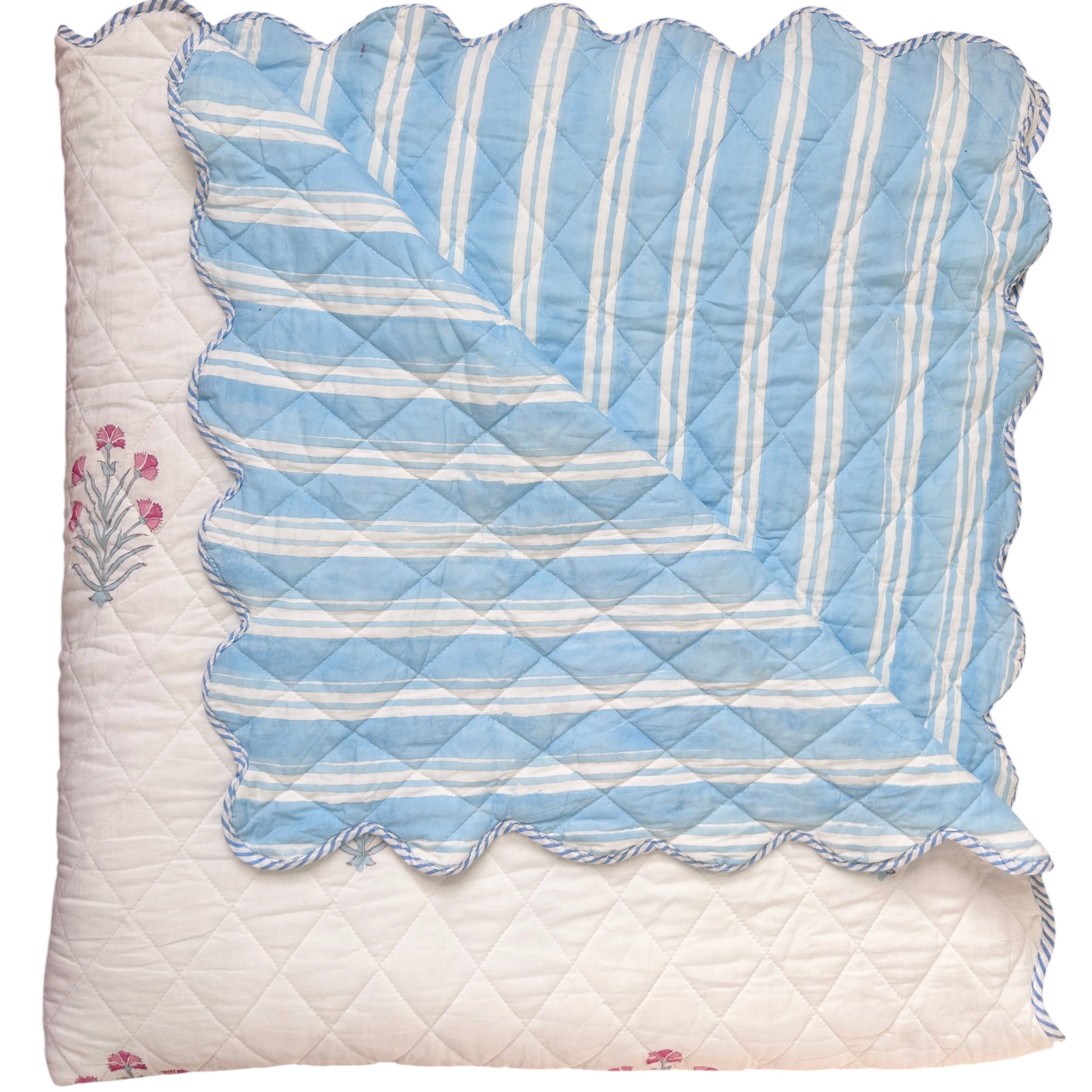 hand block printed Quilt with blue and white striped pattern on a white background and floral motifs. The Charpoy