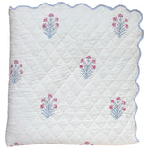 Quilted bedspread with floral hand block printed on a white background and scalloped edge The Charpoy
