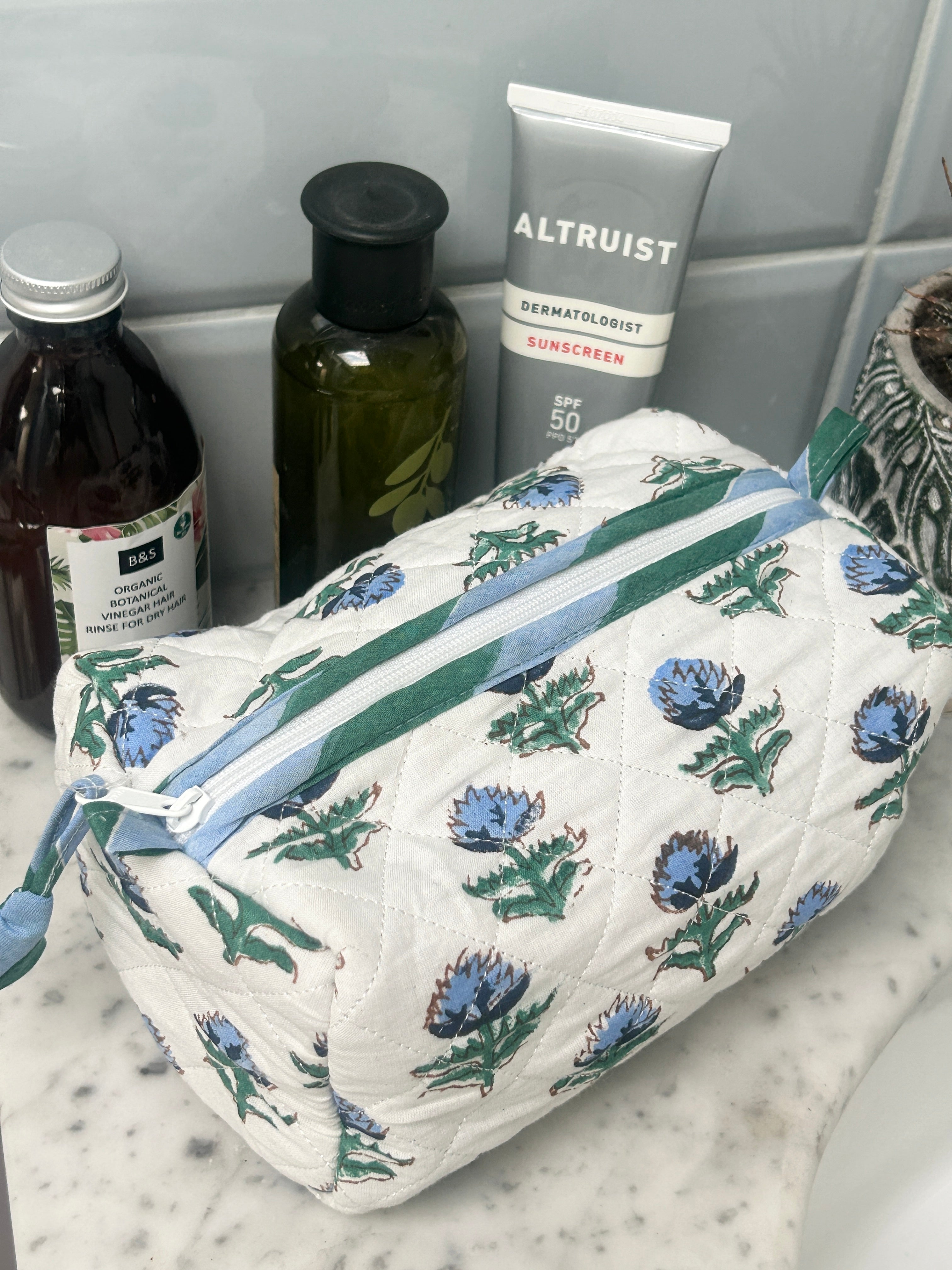 Floral-patterned toiletry bag with skincare products on a bathroom counter The Charpoy 