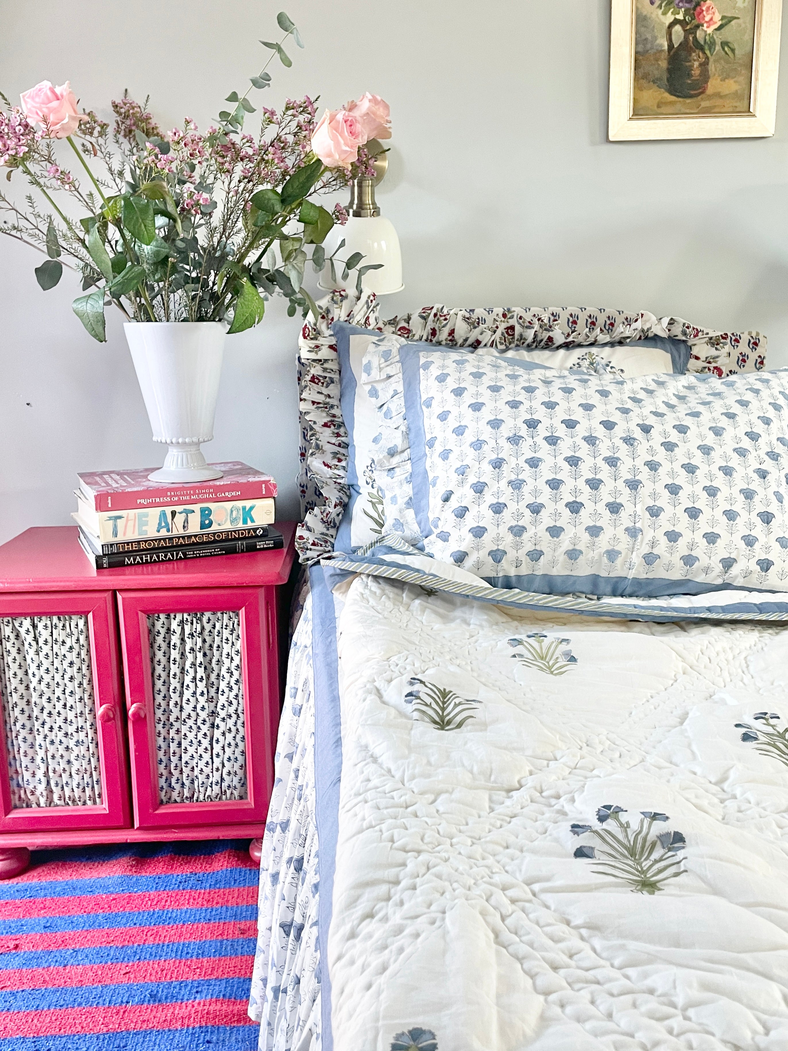 Blue Buta Hand block printed Quilt draped on a bed with floral motifs, handmade by artisans in Jaipur by The Charpoy