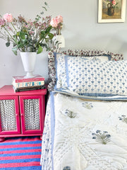 Blue Buta Hand block printed Quilt draped on a bed with floral motifs, handmade by artisans in Jaipur by The Charpoy