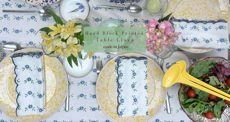Table setting with floral Petit Blue tablecloth, plates, and cutlery with matching scalloped napkins by The Charpoy
