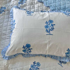 White pillow with blue floral hand block printing on a matching bedspread. the Charpoy