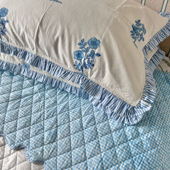 hand block printed bedspread with blue florals pillow cover on a white background The Charpoy