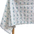 Close up of the blue petit daisy block printed motifs and embroidered scalloped border on a white cotton tablecloth by The Charpoy