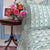 floral striped bedspread, side table with flowers. The Charpoy