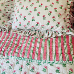 Pink And Green Carnation Hand Block Printed Quilt with matching pillows  on a bed in single, king and super king sizes. handcrafted in Jaipur by The Charpoy