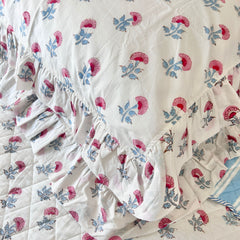 Floral-patterned fabric with ruffled edge on a white background pillow covers. The Charpoy