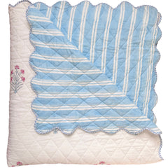 hand block printed Quilt with blue and white striped pattern on a white background and floral motifs. The Charpoy