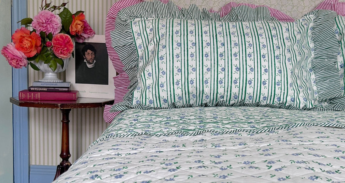 Hand Block Printed Petit blue flowers Bedspread on a bed. The Charpoy
