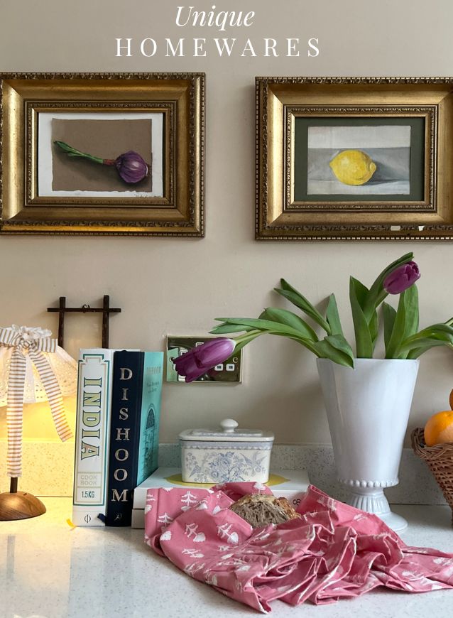 Unique homewares by The Charpoy with framed artwork, books, a lamp, a vase with flowers and and block printed towel.